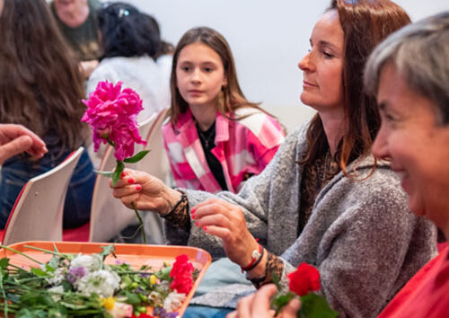 Women smiling and holding flowers at the retreat, May 2025.