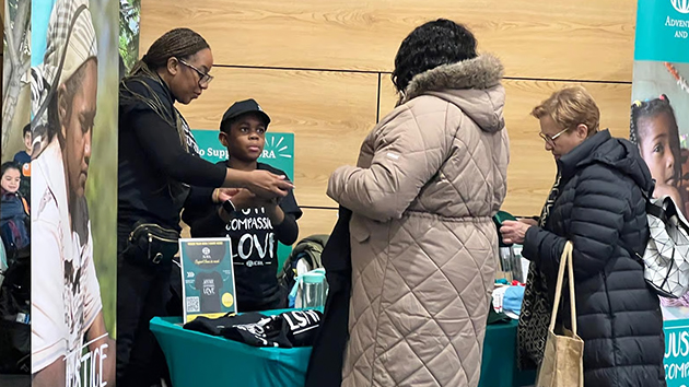 Members of the ADRA-UK team speak with event attendees at the organisation’s exhibition stand during the Evangelism Expo