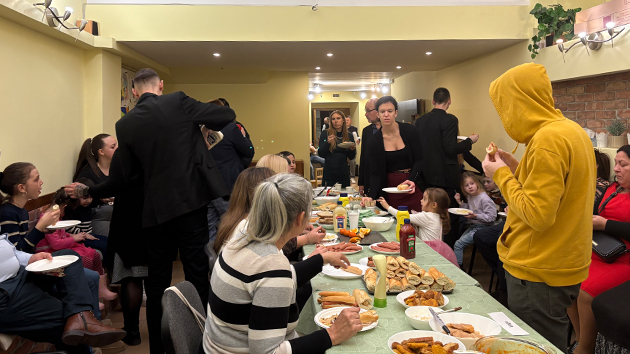 Church members share a meal and conversation together during the “Hot Dog Night” programme