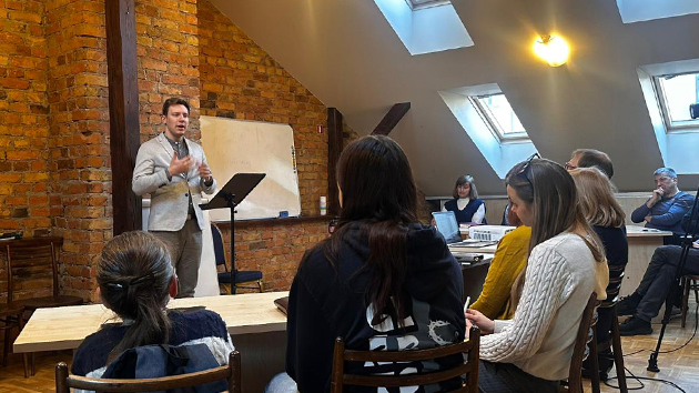 Pastor Miks Možeiko speaks during the opening devotional in Riga, Latvia, encouraging participants in their mission to plant churches