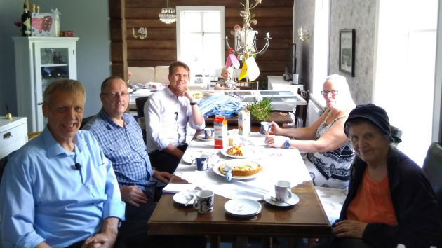 Pastor Sakari Vehkavuori, great-grandson of Viktor Ståhlberg, sits with Victor Hulbert, Pastor Atte Helminen, another great-grandson, a young family member, Helena Kumpunen and Sointu Helminen, Viktor Ståhlberg’s granddaughter, during filming in Finland