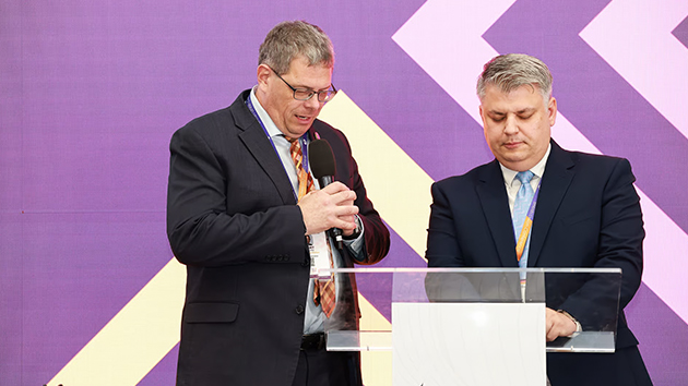 Robert Csizmadia, Trans-European Division Executive Secretary, prays with Emanuel Bran after Bran was elected Executive Secretary of the British Union Conference