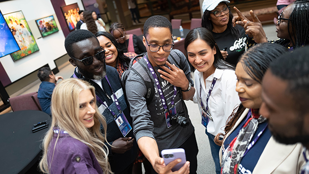 Content creators smile as they collaborate with new individuals during the global Creator Summit