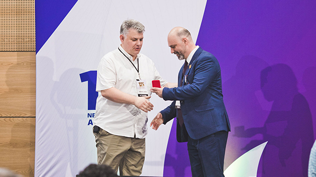 Newbold College Principal Dan Serb (right) presents a commemorative coin to Emanuel Bran, who was elected British Union Conference Executive Secretary a few days after the anniversary weekend