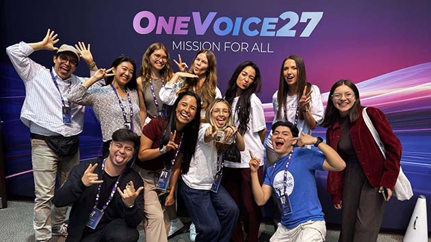 Group of young influencers at the creators summit, with One Voice 27 banner behind